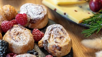 A variety of pastries and berries on a slate serving board.