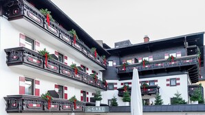 Ett hotell med flera våningar, där balkongerna är dekorerade med röda band och grönska.