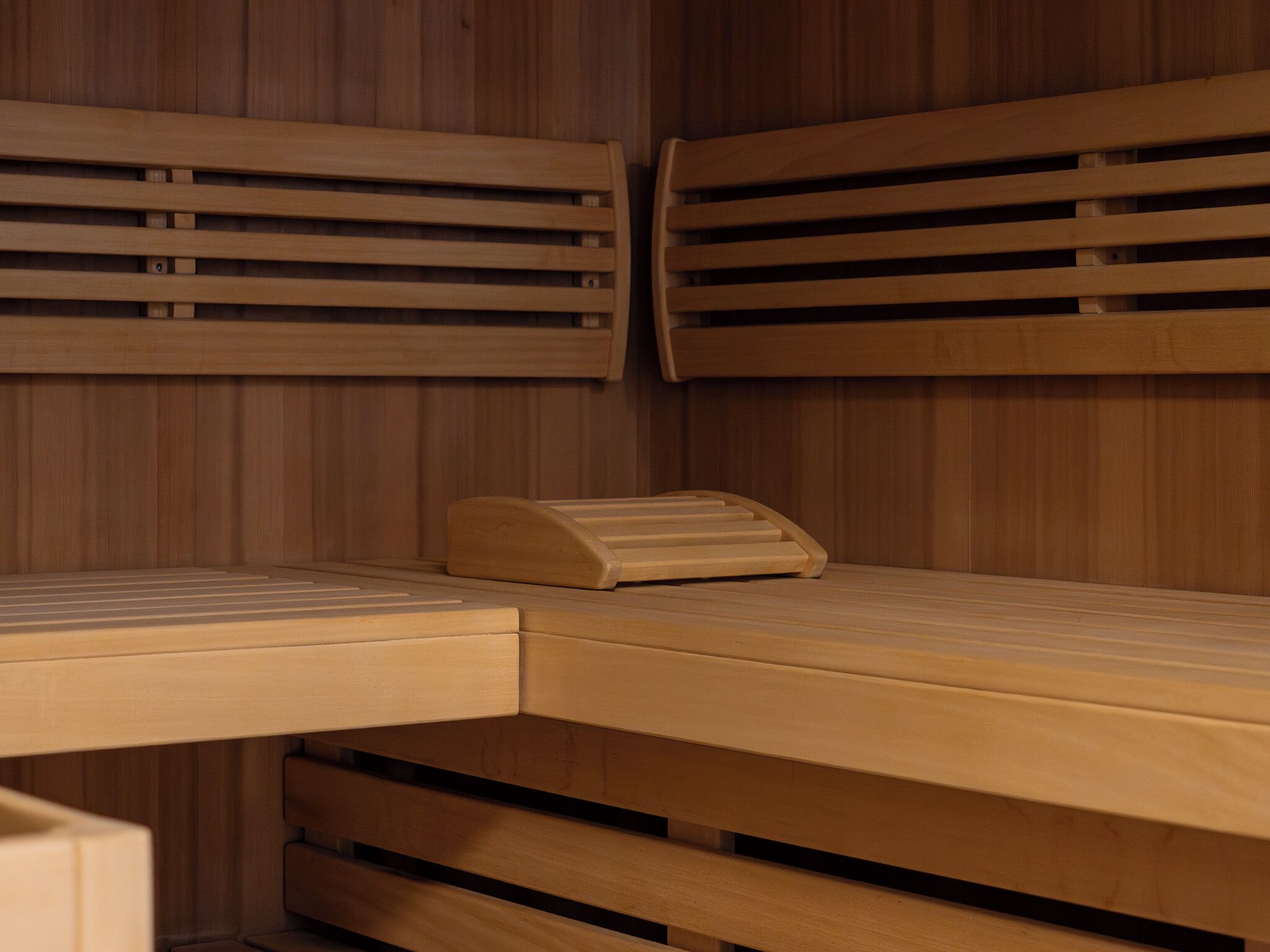 Una sauna de madera con bancos y un asiento.