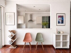 Um interior moderno com duas cadeiras, uma estante e um armário branco.