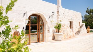 A white building with a large arched entrance, a chimney, and potted plants. - Hasamami Luxury Villa in Ostuni, 4 double bedrooms, private pool  (Ostuni)