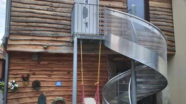 A wooden house with a spiral staircase, a swing, and a grill outside. - Maisonnette (Wintzenheim)