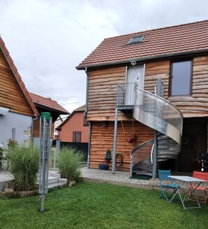 A wooden house with a spiral staircase leading to a second floor.