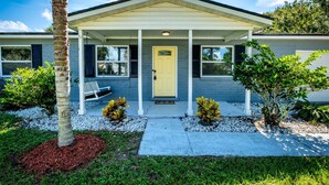 A modern two-story house with a covered porch, a yellow front door, and a small garden with plants and a bench. - Sweet Home Ponte Verdra: TPC Golf+Park+Outdoor Fireplace+ Nearby Beach Access！ (Ponte Vedra Beach)