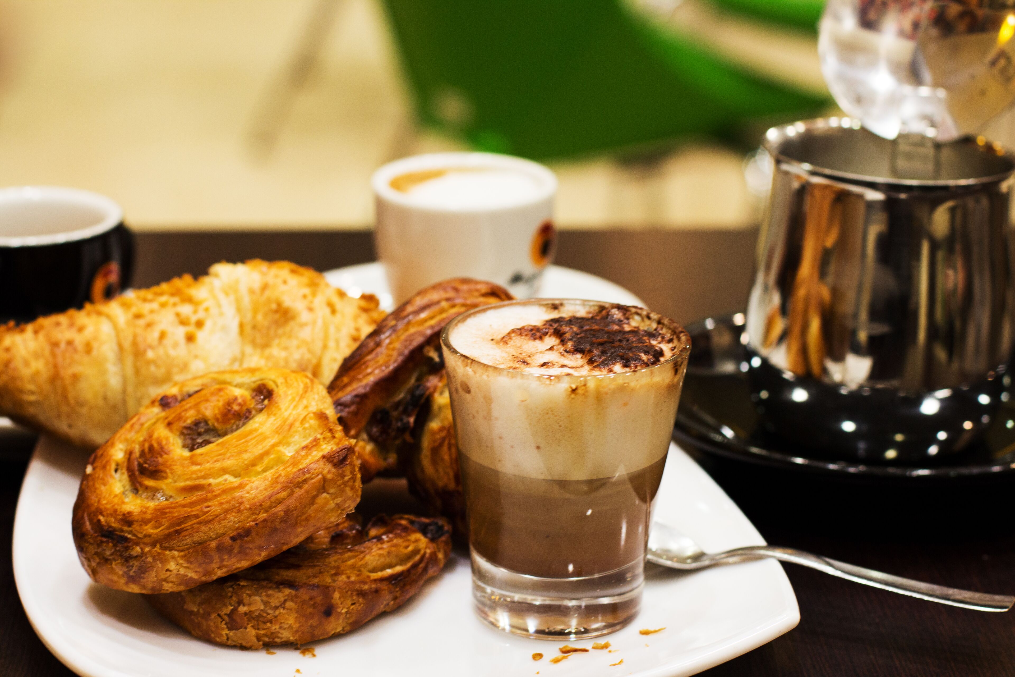Un plato de pasteles y una taza de café sobre una mesa.