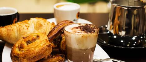 A plate of pastries and a glass of coffee on a table.