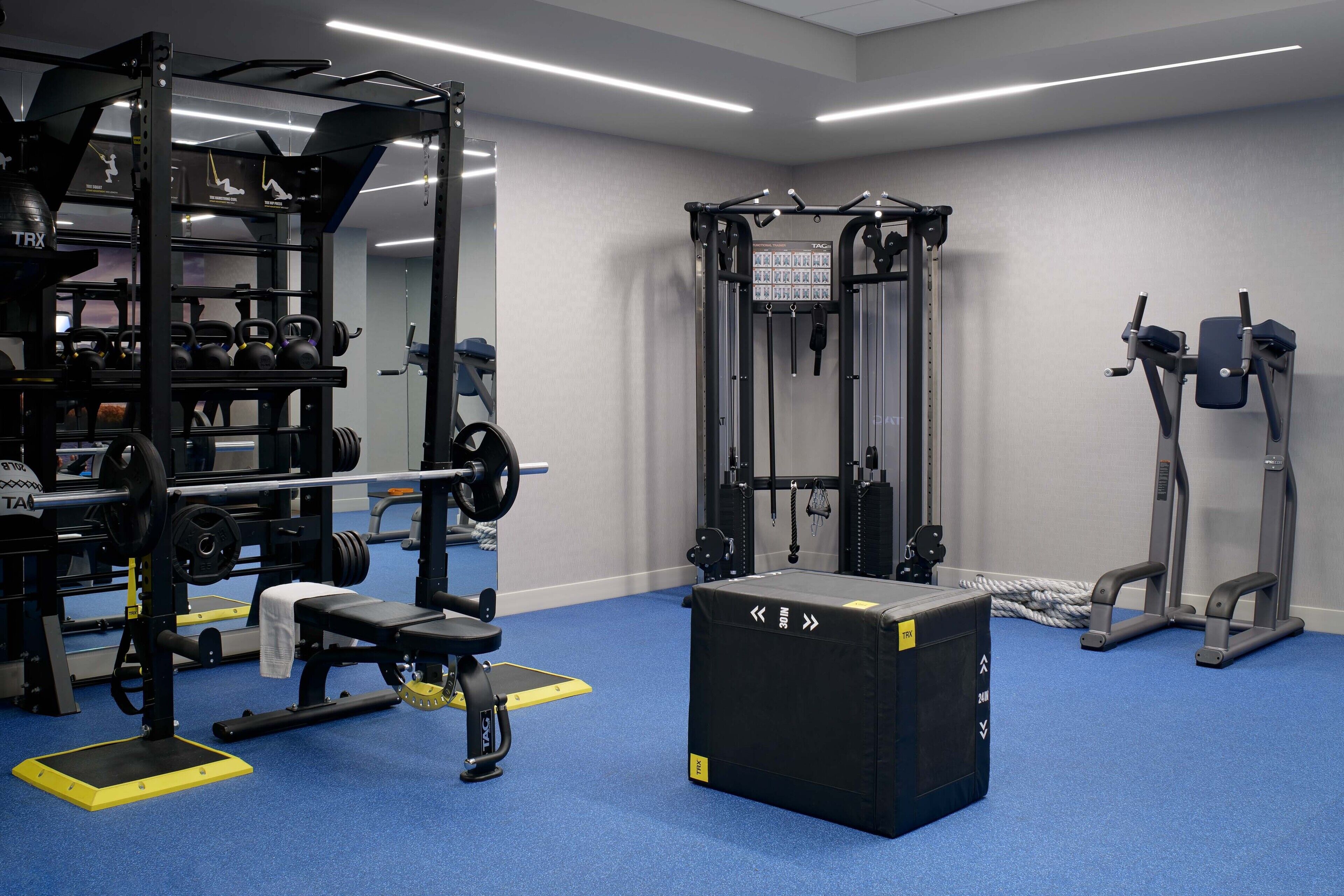 A gym with weightlifting equipment, a pull-up bar, and a bench.