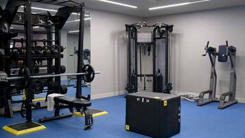 A gym with weightlifting equipment, a pull-up bar, and a bench.
