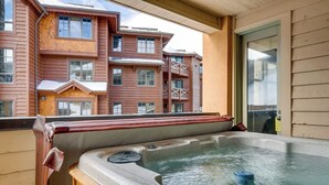 Un jacuzzi en un balcón con vistas a un edificio de varios pisos.