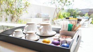 A tray with white cups and saucers, a coffee machine, and a container with coffee pods and a book. - Rock House (Providenciales)