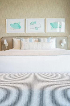A bed with a striped pillow, a headboard, and a wall-mounted lamp. - Rock House (Providenciales)