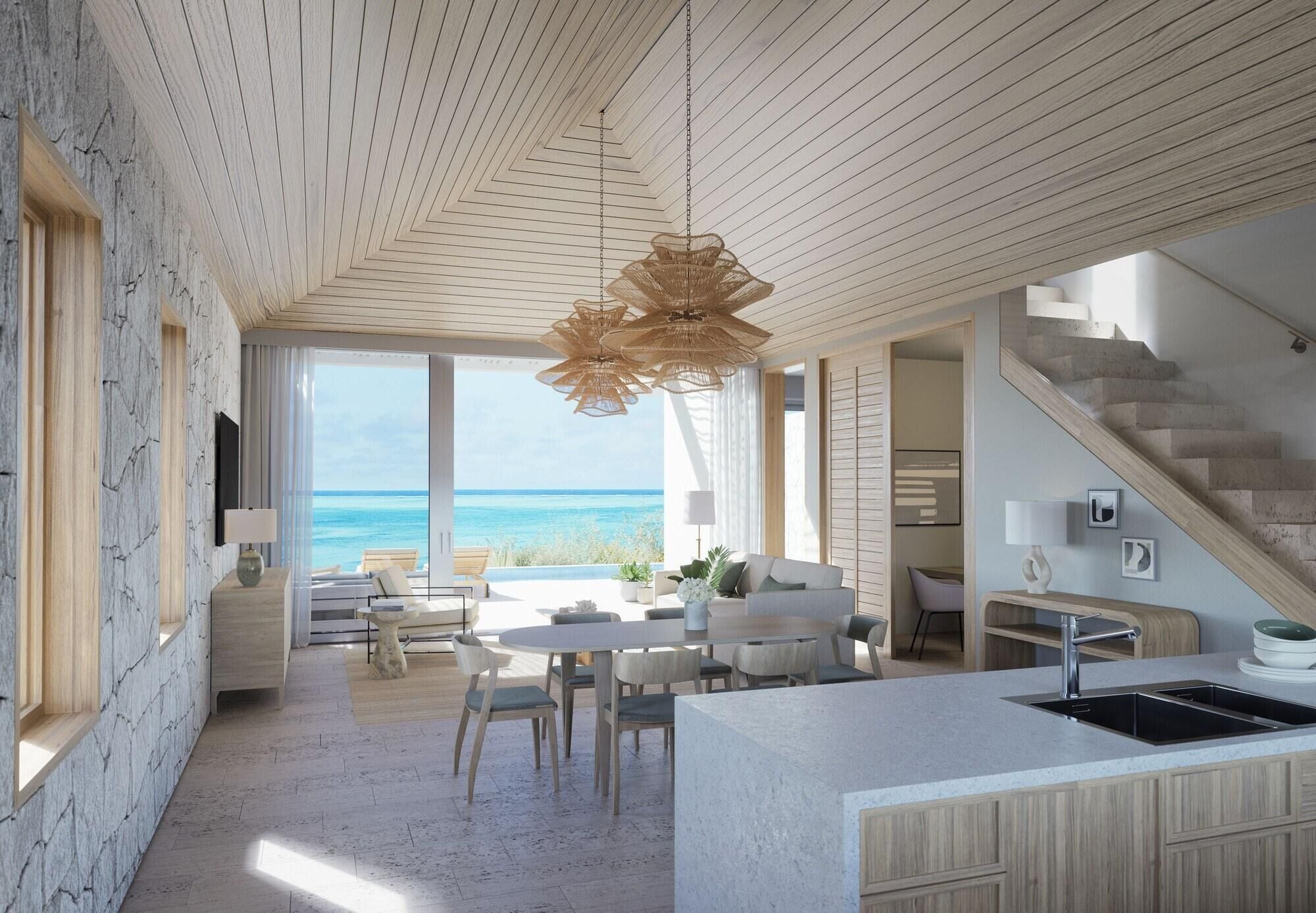 Un interior moderno con isla de cocina, comedor y vista al océano.