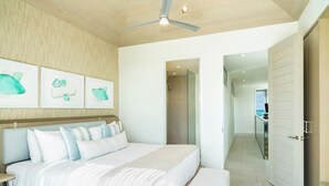 A modern bedroom with a large bed, a ceiling fan, and a view of the balcony. - Rock House (Providenciales)