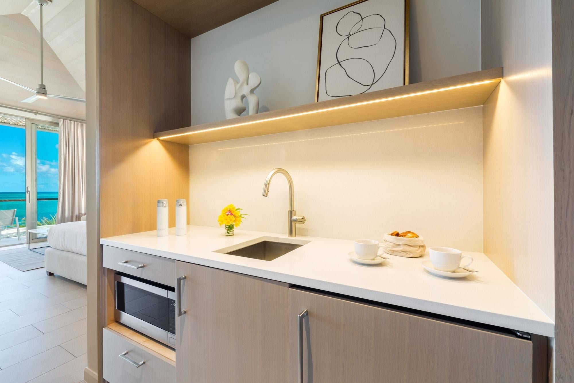 A modern kitchen with a sink, countertop, and cabinets.