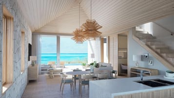 A modern interior with a kitchen, dining area, and a view of the ocean.