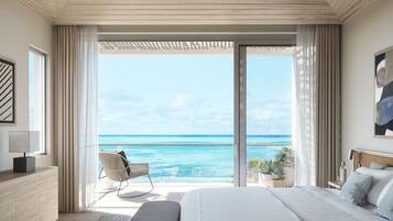 A bedroom with a large bed, a chair, a bedside table, and a view of the ocean.