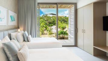 A bedroom with a large bed, a TV, and a sliding glass door leading to a garden.