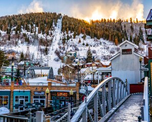 A ski resort town with a mountain backdrop, a ski lift, and a building labeled 'Park City Mountain'.