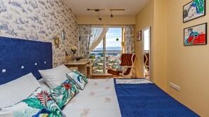 Une chambre d’hôtel avec un lit, un bureau, une chaise et une vue sur la ville.