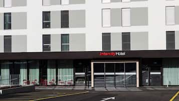 Un moderno Hotel Intercity con fachada plana, amplias ventanas y un estacionamiento con carriles exclusivos para bicicletas.