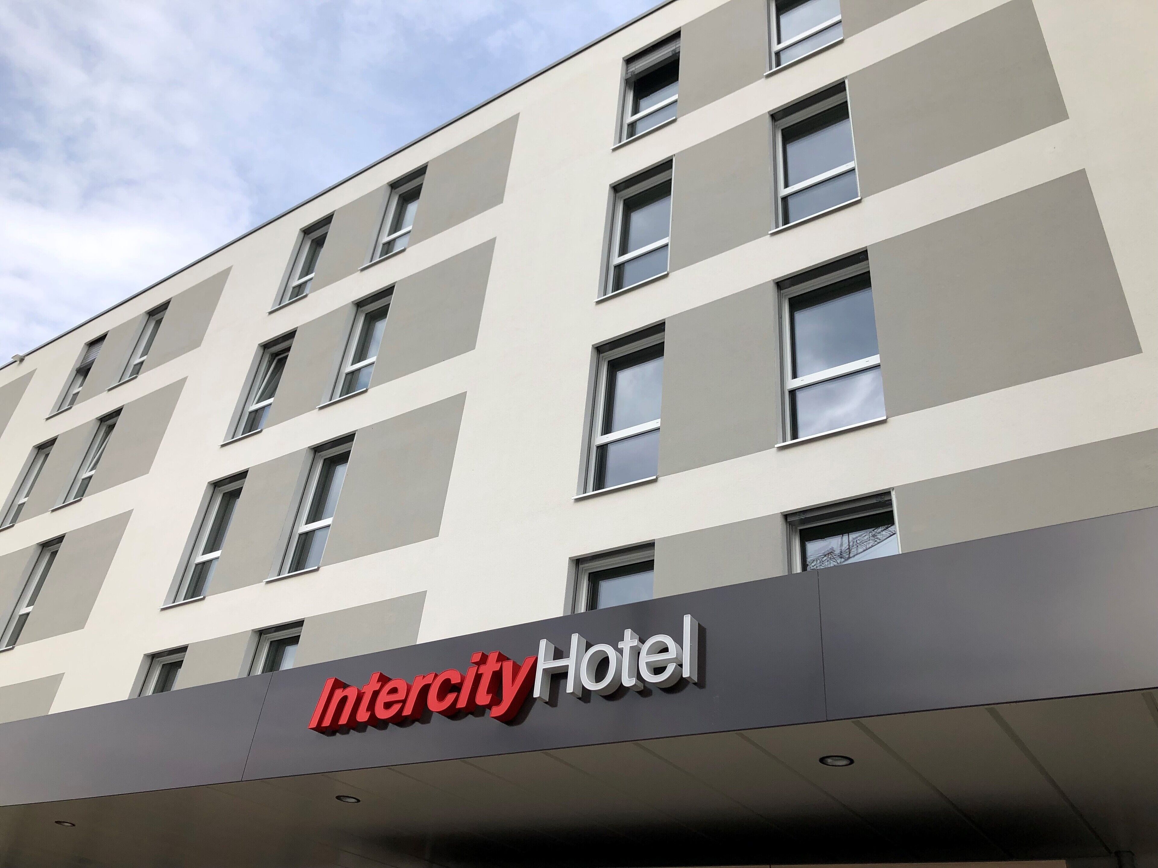 Un edificio moderno del Hotel Intercity con fachada plana, numerosas ventanas y un cartel llamativo.