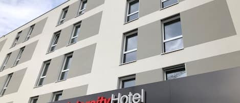 Un edificio moderno del Hotel Intercity con fachada plana, numerosas ventanas y un cartel llamativo.