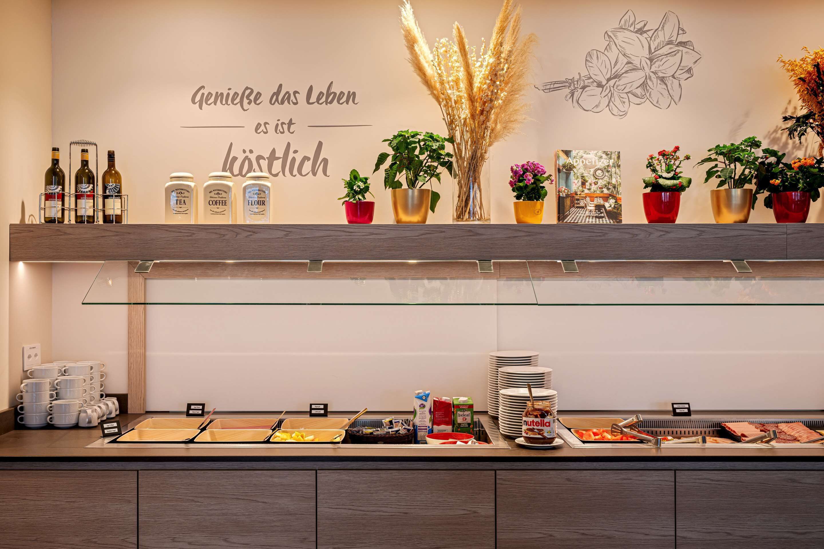 A buffet area with various food items, condiments, and a glass display case.