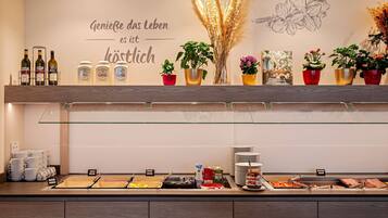 A buffet area with various food items, condiments, and a glass display case.