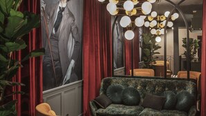 A modern interior with a large portrait, a unique chandelier, and a patterned sofa. - Dandy Hotel  (Paris)