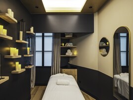A modern bedroom with a large bed, wooden shelves, and a mirror.