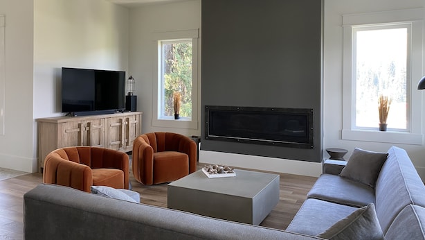 Un salon moderne avec un téléviseur à écran plat, une cheminée et un canapé.
