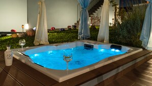 A hot tub with a glass and bottle on the side, surrounded by greenery and a staircase. - Cottage Pearl-Rural Holiday Experience by SeaPearl.. (Paul do Mar - Calheta)