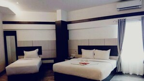 A hotel room with two beds, a large mirror, and a modern design.