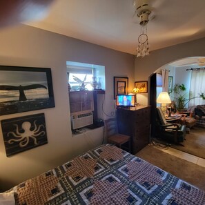 A cozy room with a bed, a desk with a computer, a TV, and a window with a view of the sea. - Cozy Garage Apartment
 near Blacksburg, Christiansburg and Radford, Va. (Christiansburg)