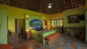 A room with a bed, a desk, and a chair. There is a painting on the wall and a window with curtains. - El Corazón Golf & Spa Resort Manzanillo (Manzanillo)