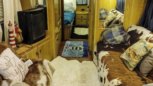 Ein kompaktes Wohnmobil-Interieur mit Schlafbereich, einer Küchenzeile und einem Badezimmer.