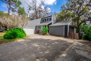 A two-story house with a garage, a covered porch, and a small detached garage.