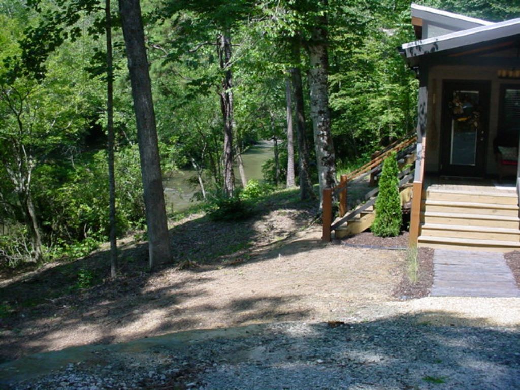 A wooden staircase leading to a building surrounded by dense forest.