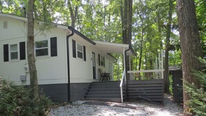 A cabin with a porch, steps leading to a door, surrounded by trees. - LAKEFRONT Retreat! <br>Escape To Lake Hartwell in this lakeside cottage!  (Lavonia)