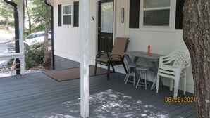 A covered porch with a table and chairs, a door, and a tree. - LAKEFRONT Retreat! <br>Escape To Lake Hartwell in this lakeside cottage!  (Lavonia)