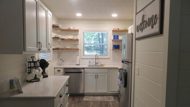 A kitchen with white cabinets, a window, and a welcome sign. - LAKEFRONT Retreat! <br>Escape To Lake Hartwell in this lakeside cottage!  (Lavonia)