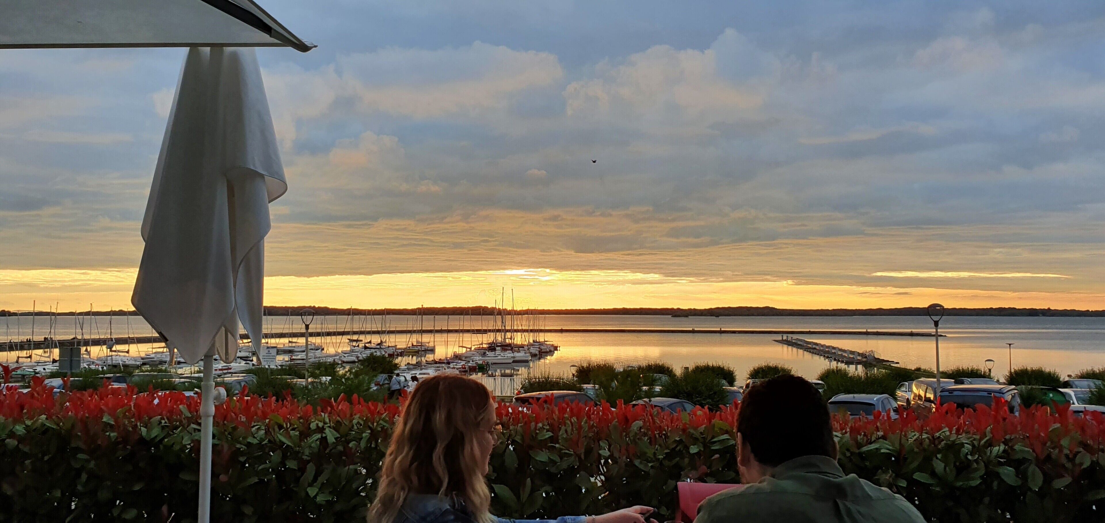 A marina with boats and a sunset view.