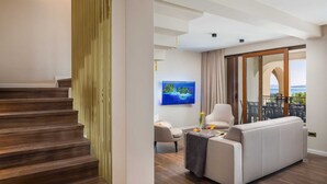 Een moderne woonkamer met een bank, een televisie en uitzicht op zee.