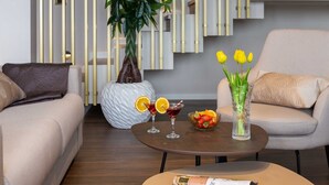 Een moderne woonkamer met twee banken, een bijzettafeltje, een plant en een vaas met gele tulpen.