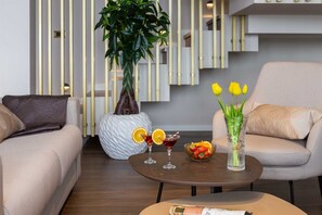 Ein modernes Wohnzimmer mit zwei Sofas, einem Couchtisch, einer Pflanze und einer Vase mit gelben Tulpen.