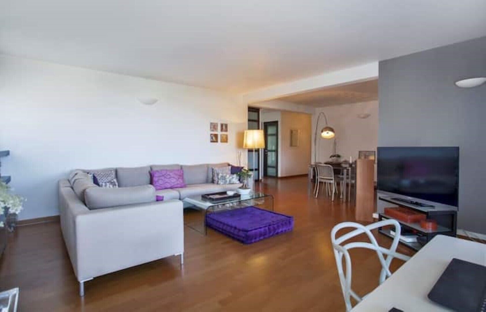 Ein modernes Wohnzimmer mit einer Couch, einem Couchtisch und einem Fernseher.