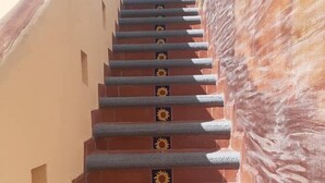 A staircase with red steps and blue handrails, leading up a building. - Honeymoon suite with private jacuzzi DISCOUNTED RATE (Loreto)
