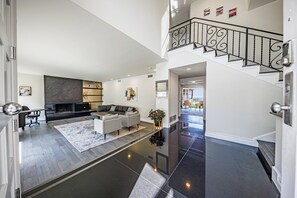 Un amplio salón con una chimenea moderna, un sofá modular y una mesa de comedor.