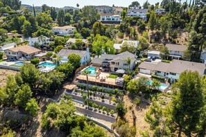 Un quartier résidentiel comprenant plusieurs maisons, une piscine et un jardin aménagé.