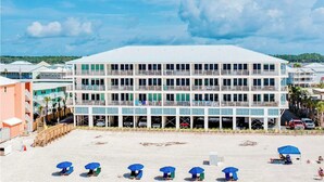 Monikerroksinen hotelli, jossa on tasakatto, useita parvekkeita ja pysäköintialue edessä.